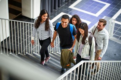 Studierende gehen eine Treppe im Universitätsgebäude hoch